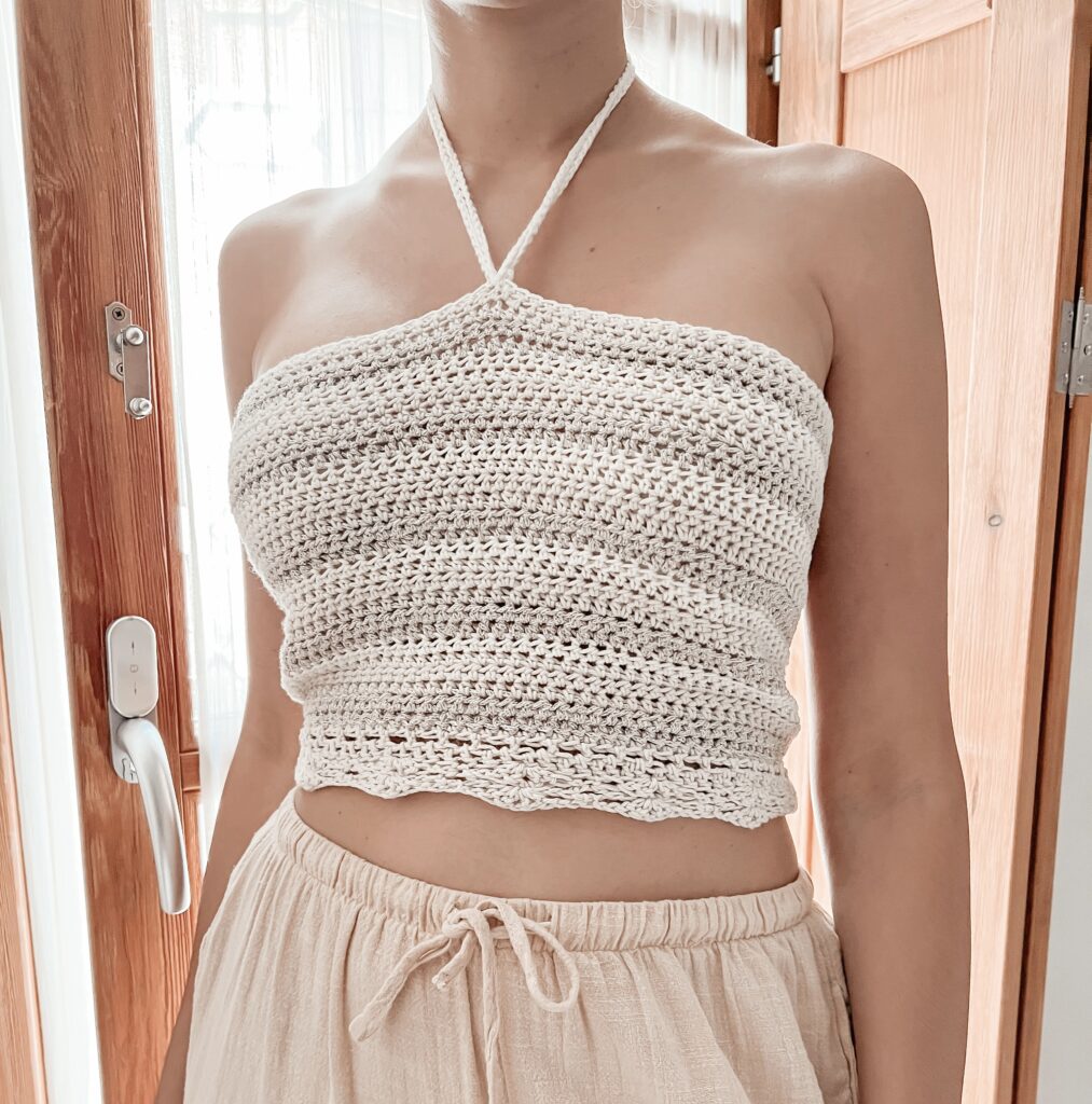 Close-up of Joelyne showcasing the intricate stitch work on her Halter Hues top, made from the free crochet halter top pattern.