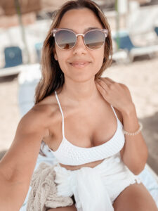 Joelyne at the beach in Spain, wearing the Sienna crochet bralette and enjoying the sun and sea.