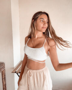 Joelyne wearing a white Sienna crochet bralette, showcasing the Alpine Stitch detail.